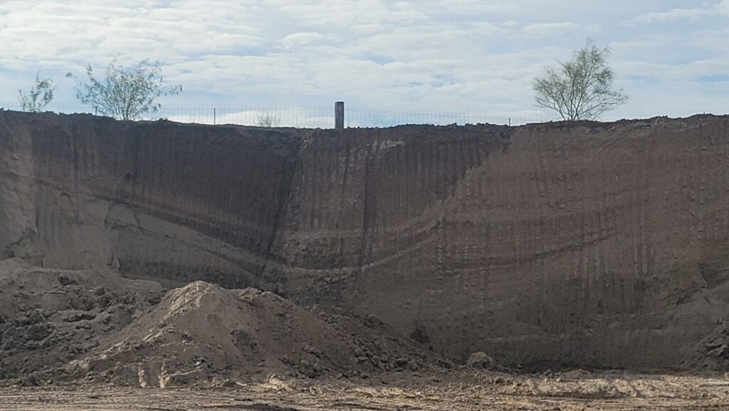 A 30ft high sand bank inside a quarry used near the Rio Grande river in Texas showing all its layers compressed into curves in a quarry in Texas